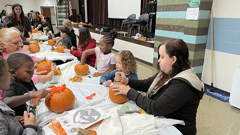 Families helping their students with their pumpkins.