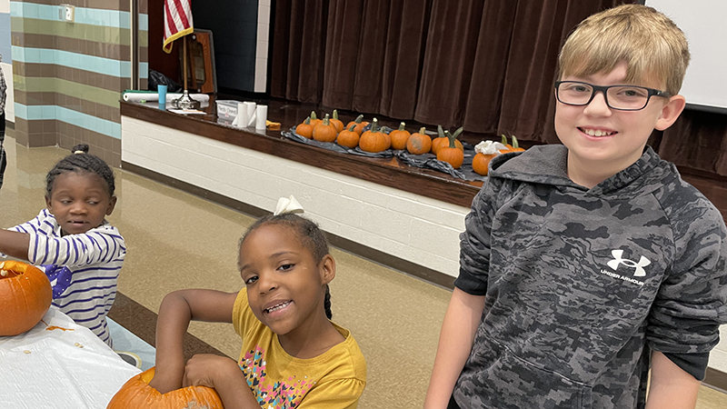 A student council member helps a kindergarten student.