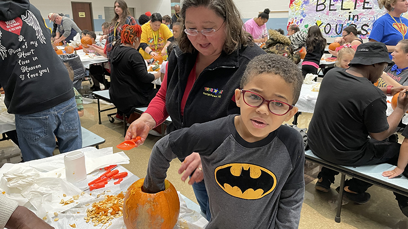 A student cleaning out his pumpkin.