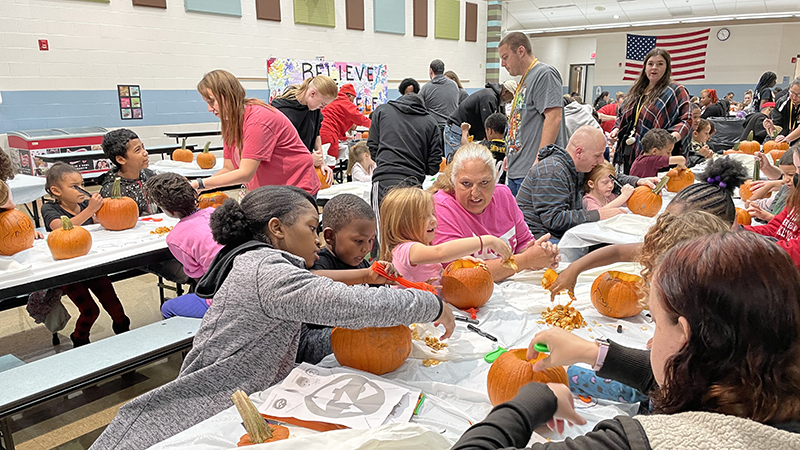 Families helping their students with their pumpkins.