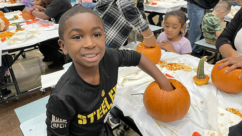 a student cleaning out his pumpkin.