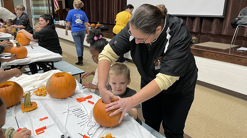 Mrs. Hartzell helps clean out a pumpkin.