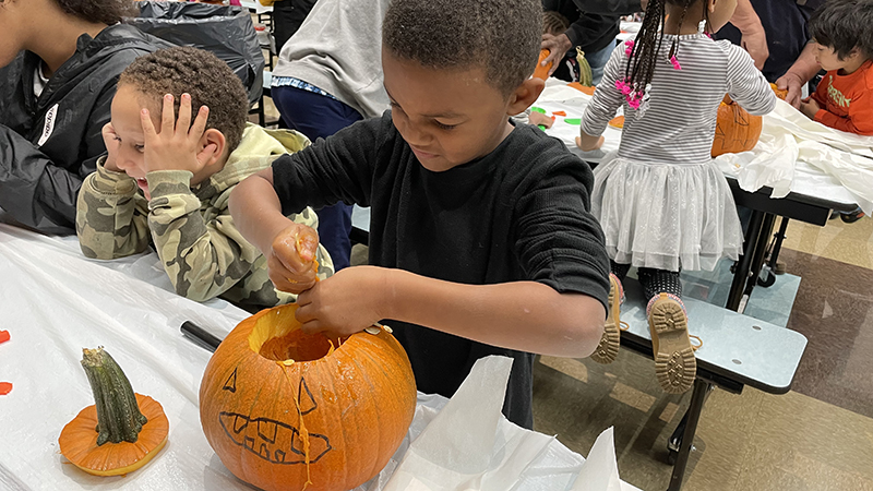 A student cleans out his pumpkin.
