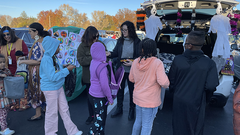 Sixth grade teachers pass out candy to families.