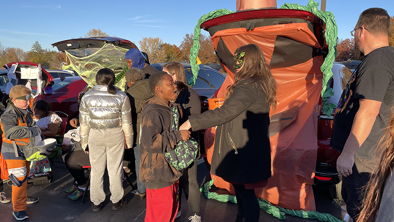 Ms. Komsa passing out candy to a student.