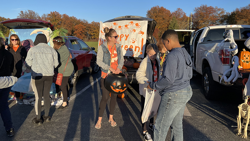 A kindergarten teacher passing out candy.