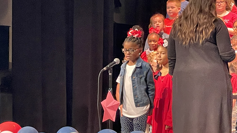 A student reciting the lines to a poem during the concert.