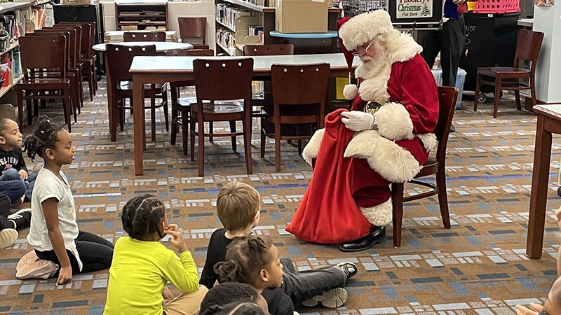 Santa shows students the special treat he brought in his bag.