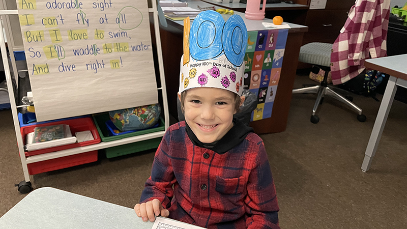 A student shows off his 100th day hat that he colored.