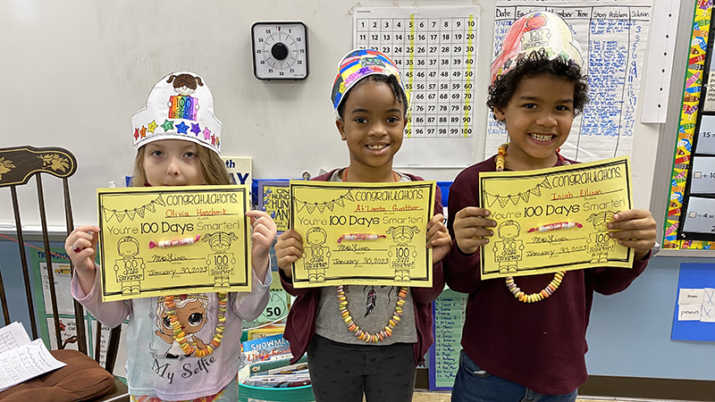 First graders show off their certificates they received for becoming one hundred days smarter.
