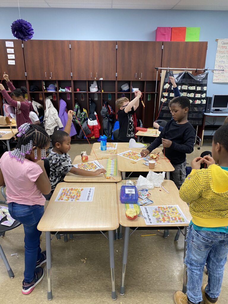 first graders complete an activity for the 100th day of school.