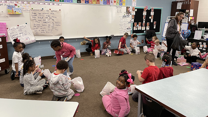 Students wait patiently in a circle while their classmates pass out Valentines.