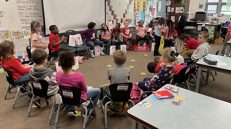 A kindergarten class passing out Valentine's.