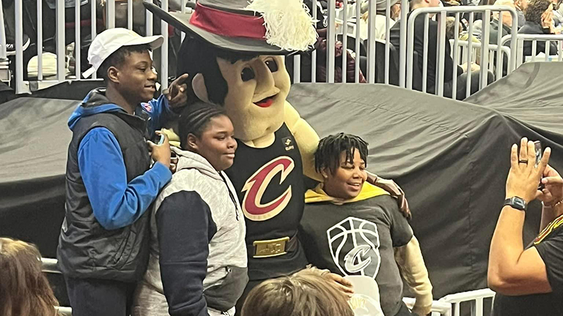 Three students get to meet the Cavs mascot.