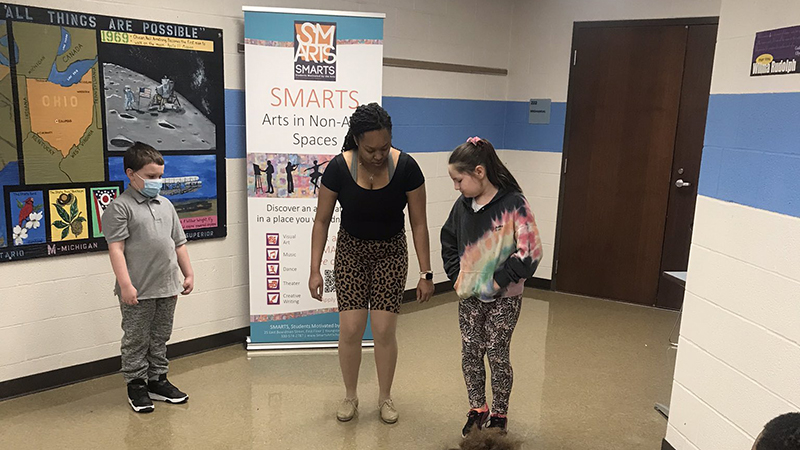 Student volunteers listen to the SMART's dancer as she gives instructions.