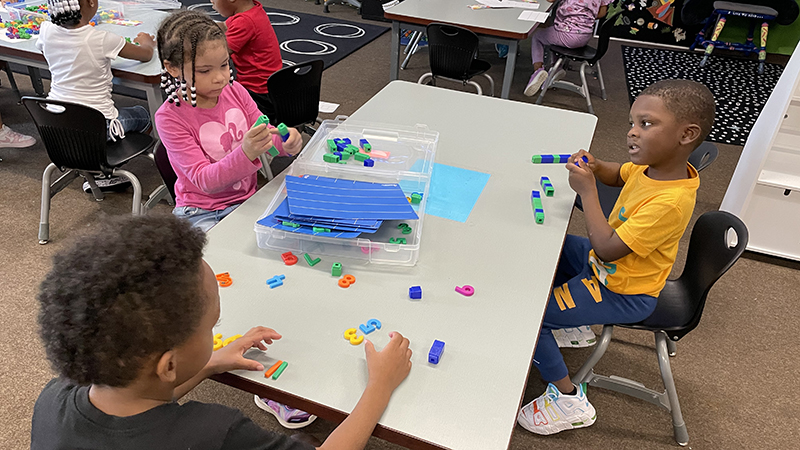 Students share math blocks and practice their counting.