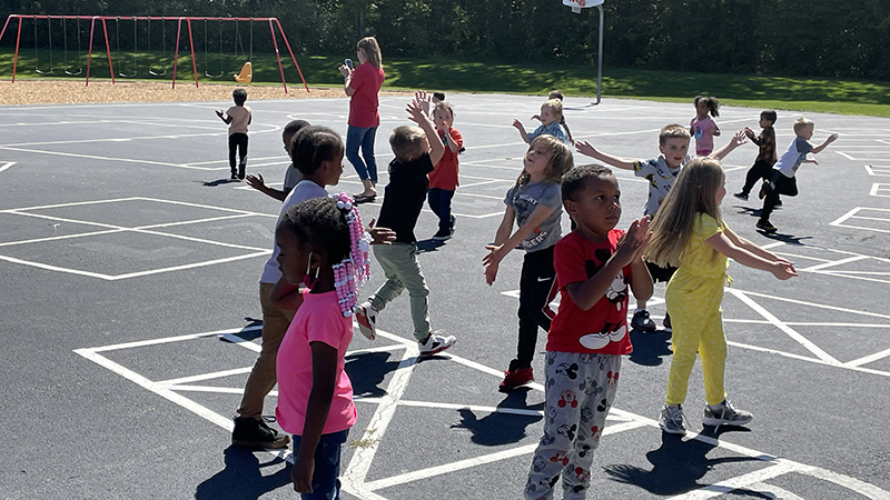 Students have a dance party on the playground.