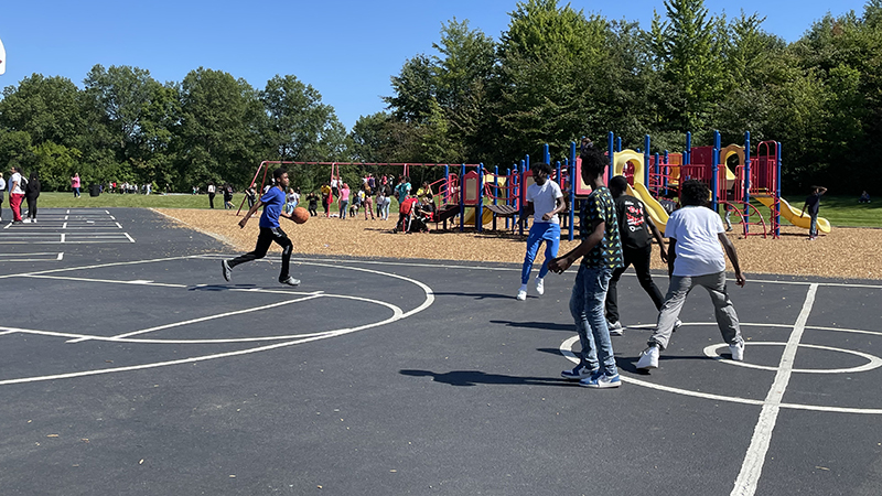 Students play basketball during the tailgate party.