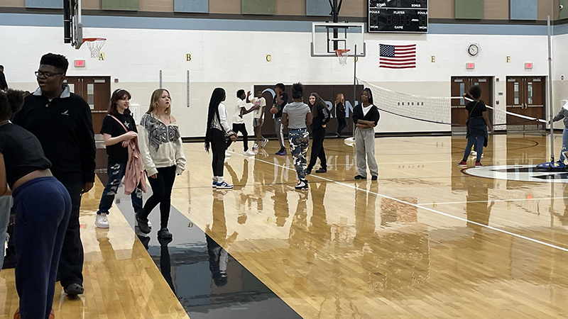 6-8 students enjoy time together in the gym.