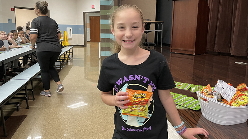 Student shows her reward for winning bingo game.