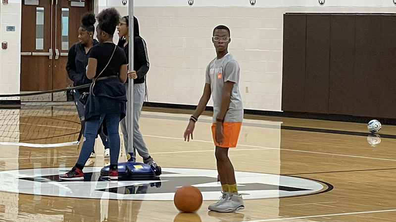 A student enjoys time playing basketball.