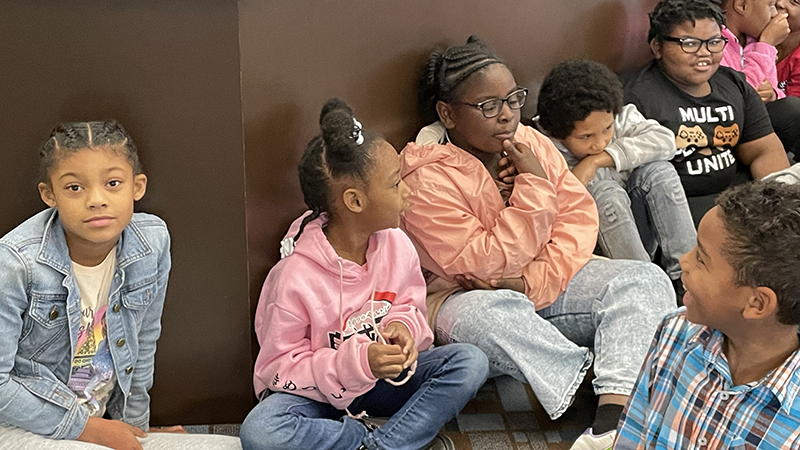 Students gather and wait for story time to begin.