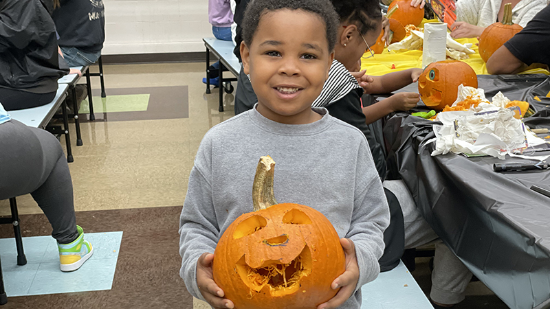A student shows off his finished pumpkin.