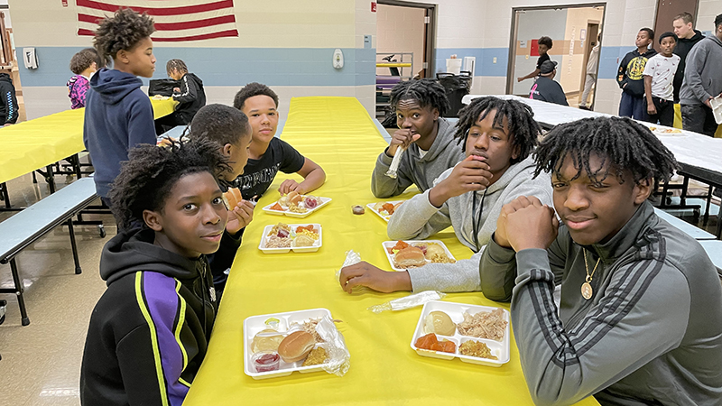 Seventh and eighth grade boys enjoy their meal together.