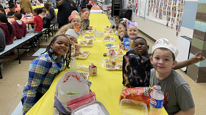 Miss McMenamin and her students having lunch together.