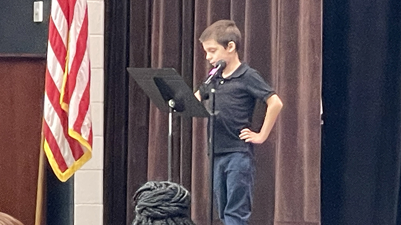 A student reads a poem in honor of veterans.