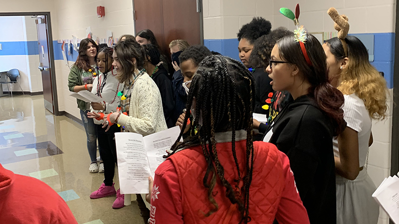 Choir students sing carols for third grade students.