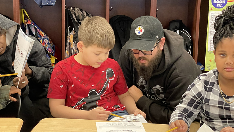 A student explains to his guest the activity.