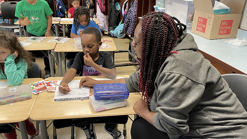 A student and his guest read the directions for their activity.