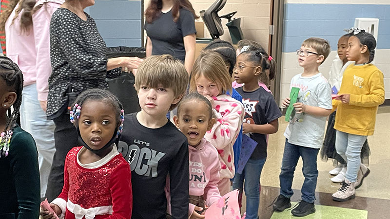 Students wait patiently for their gifts.