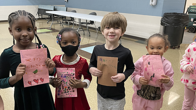 Students show the thank you cards they made for the church.