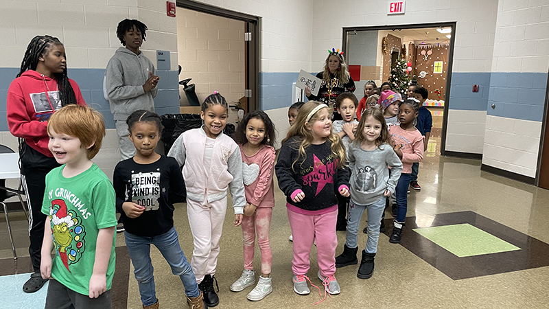 First graders wait patiently for their gifts.