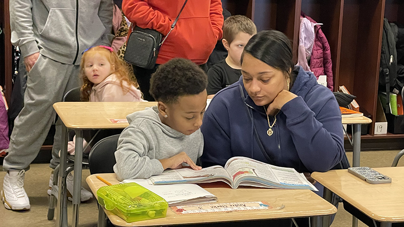 A student reads to his guest.