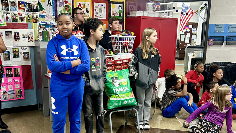 Students wait as others gather to see what was purchased for the dog pound.