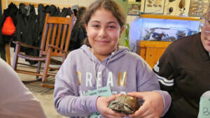 A student holds one of the turtles.