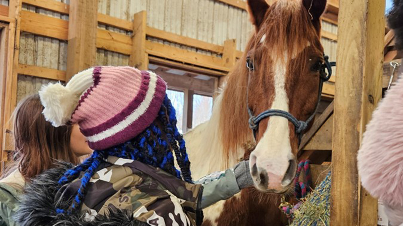 Students visit with one of the horses at camp.