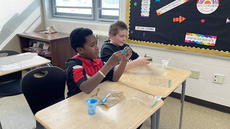 Students try a biotechnology activity by making slime.