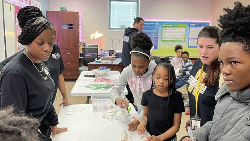 Students experiment with different scents to create lotion.