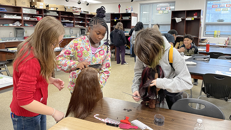 Students get to practice hairstyles on mannequins.