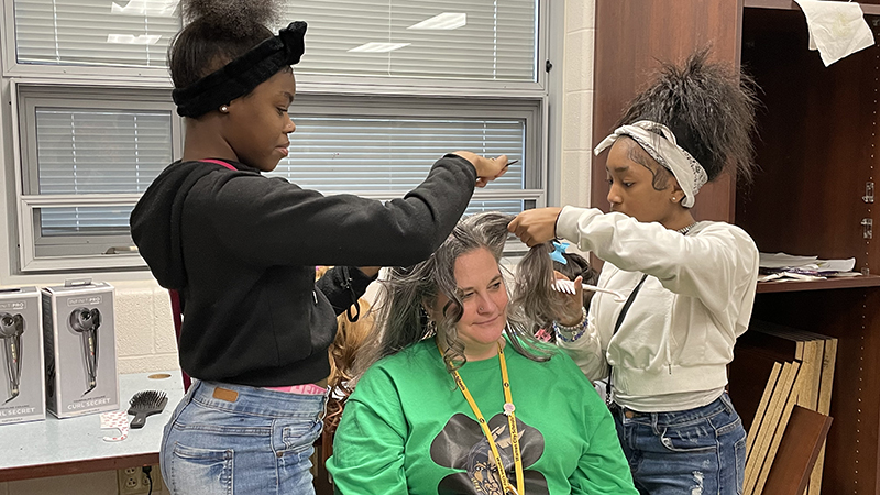 Mrs. Hunchuck volunteers to have students try out a new hair style.