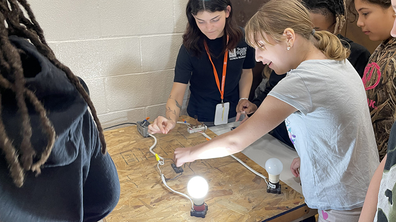 A student gets guidance from an electrical technician TCTC student.