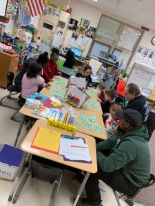 1st grade students playing word game with adults