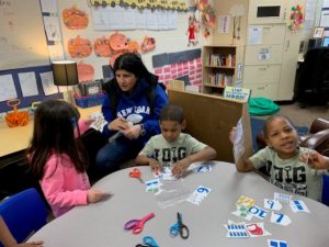 Parent with tree preschoolers at a table doing a project