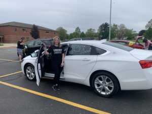 Pictures of cars in a parde with families waving