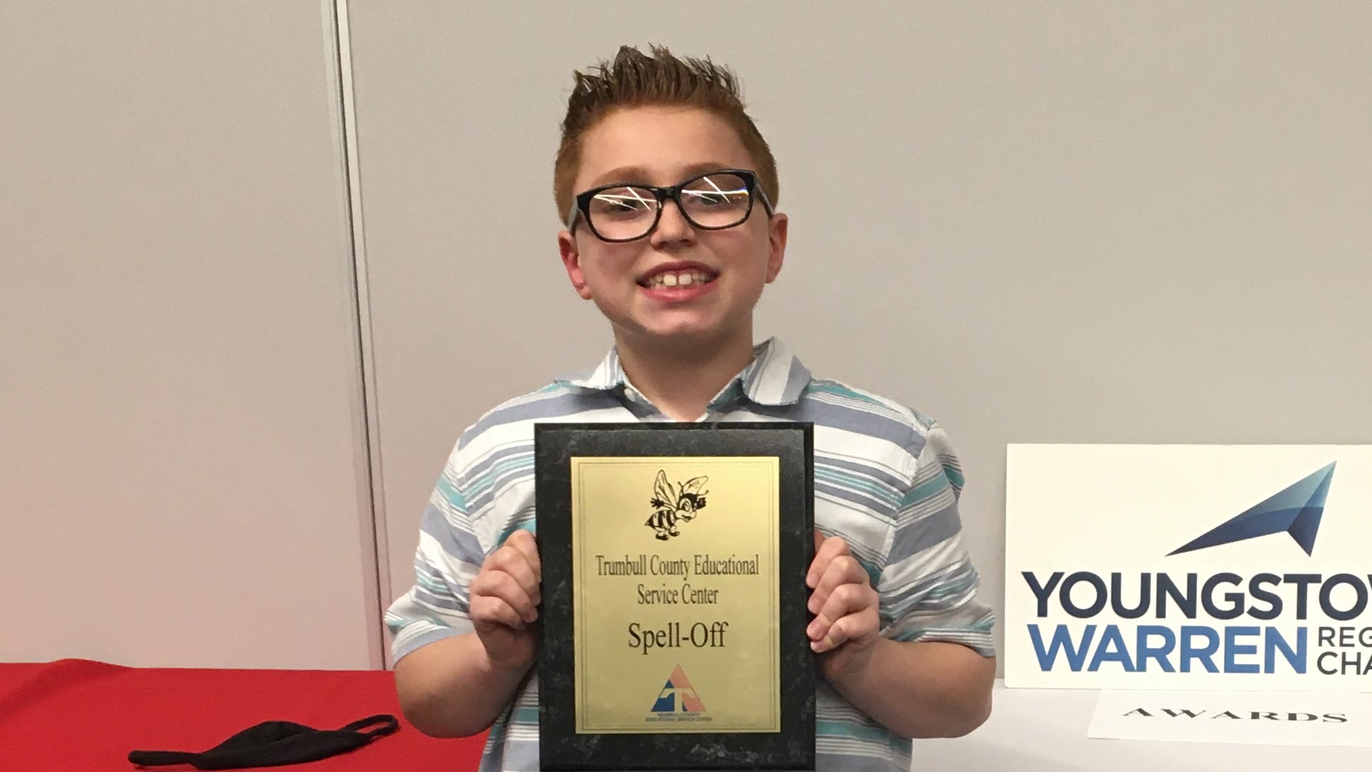 5th grade boy holding a plaque