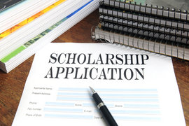 Scholarship application with pen, notebooks and papers